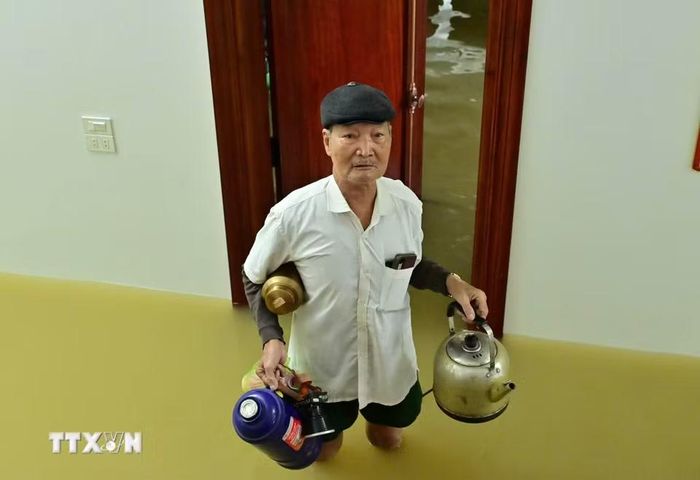 Người dân thôn Kênh Gà (Ninh Bình) vẫn duy trì nhịp sống, sinh hoạt trong mùa nước lũ. (Ảnh: Thùy Dung/TTXVN)