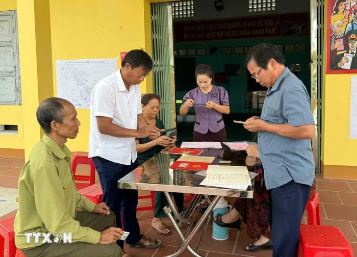 Cán bộ hướng dẫn người dân cung cấp thông tin, hồ sơ phục vụ cập nhật dữ liệu đất đai. (Ảnh: Đồng Thúy/TTXVN)
