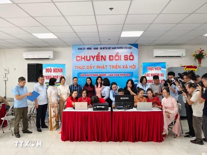 Đại biểu và người dân trải nghiệm các thiết bị, tiện ích tại mô hình “Nhà họp số” phường Cầu Giấy. (Ảnh: Trung Nguyên/TTXVN)