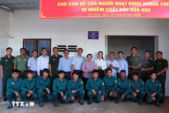 Các đại biểu cùng lực lượng vũ trang thăm và chúc mừng hộ gia đình chính sách được nhận nhà mới tại xã Gia Hòa. (Ảnh: Trung Kiên/TTXVN)