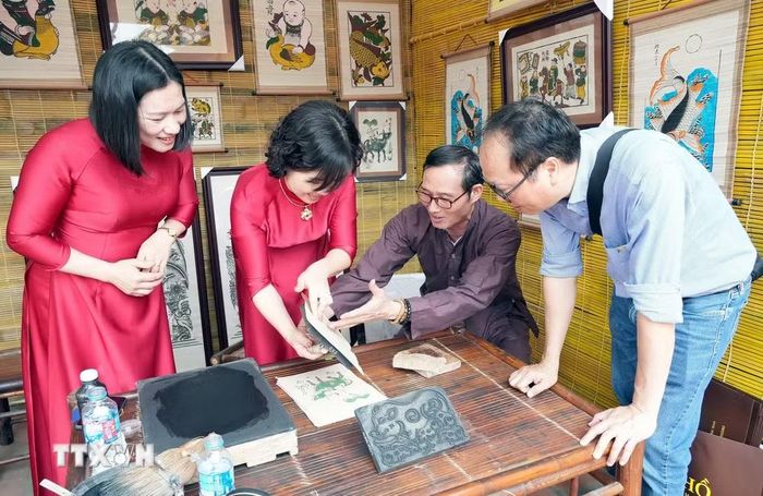 Du khách trải nghiệm in tranh dân gian Đông Hồ (Bắc Ninh). (Ảnh: Đồng Thúy/TTXVN)