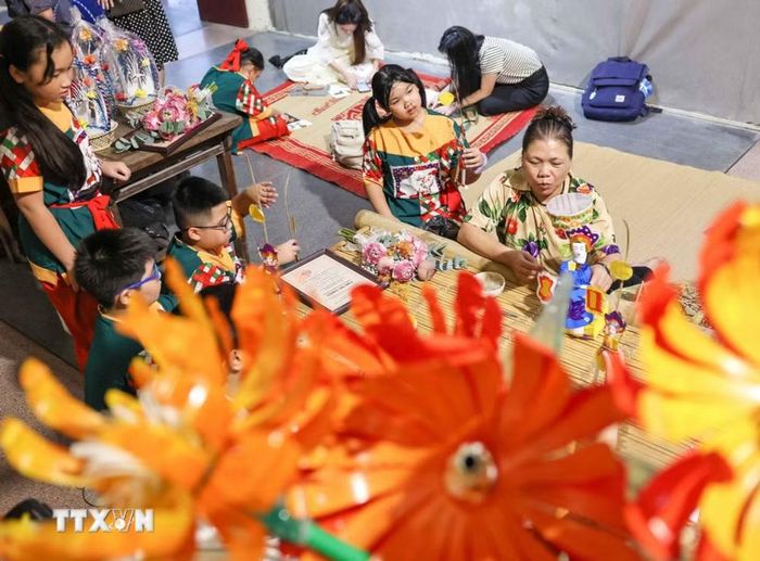 Thiếu nhi trải nghiệm không gian giới thiệu đồ chơi Trung Thu truyền thống, tham gia các hoạt động làm đèn ông sao, đèn kéo quân, tiến sỹ giấy, chuồn chuồn tre. (Ảnh: Thanh Tùng/TTXVN)
