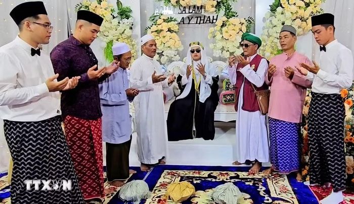 Chú rể cùng các thành viên đoàn nhà trai thực hiện nghi thức truyền thống theo đúng giáo luật Islam trước khi đoàn đưa rể sang nhà cô dâu. (Ảnh: Công Mạo/TTXVN)
