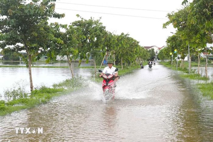 Nhiều đoạn đường dân sinh trên địa bàn các xã Diễn Châu, Đức Châu, An Châu (Nghệ An) bị ngập sâu trong nước khiến việc tham gia giao thông của người dân gặp nhiều khó khăn. (Ảnh: Xuân Tiến/TTXVN)