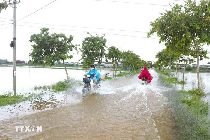 Nhiều đoạn đường dân sinh trên địa bàn các xã Diễn Châu, Đức Châu, An Châu (Nghệ An) bị ngập sâu khiến việc tham gia giao thông của người dân gặp nhiều khó khăn. (Ảnh: Xuân Tiến/TTXVN)