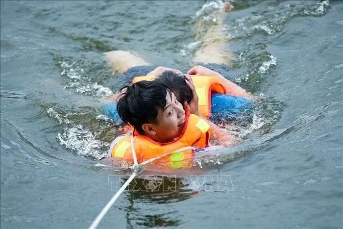 Kịch bản giả định sự cố chìm lật xuồng chở người dân, các lực lượng đồng loạt triển khai phương tiện thủy tiếp cận, tìm kiếm và vớt nạn nhân bị trôi dạt. Ảnh: Xuân Quý/TTXVN