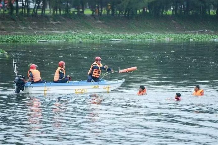 Giành giật "thời gian vàng": Cán bộ, chiến sĩ Cảnh sát PCCC & CNCH quăng phao cứu sinh, kịp thời ứng cứu các nạn nhân bị sóng đánh dạt ra xa dưới sự chỉ huy trực tiếp tại hiện trường. Ảnh: Xuân Quý/TTXVN