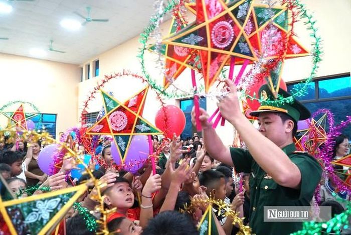Giữa không gian lung linh của đêm hội, những đôi tay bé xíu háo hức đón lấy chiếc đèn ông sao năm cánh truyền thống.