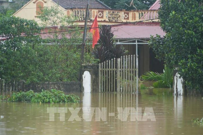 Khung cảnh mênh mông là nước, Những ngôi nhà cấp 4 chỉ thấy mỗi nóc nhà, mái ngói. Ảnh: Hoa Mai - TTXVN