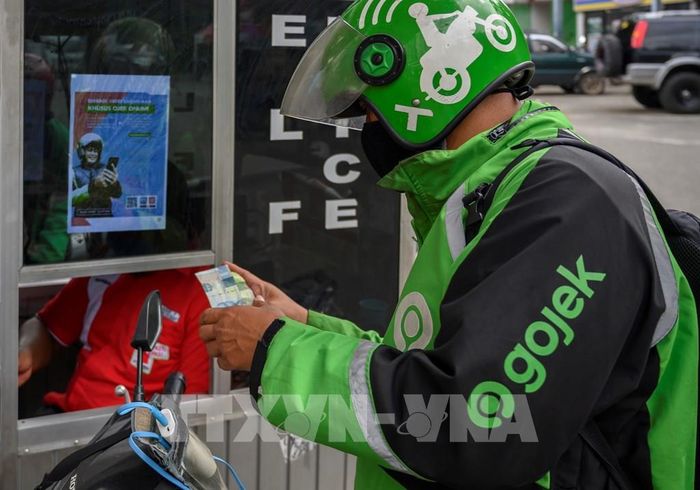 Một tài xế xe ôm công nghệ Gojek tại Jakarta, Indonesia ngày 14/4/2020. Ảnh: TTXVN phát