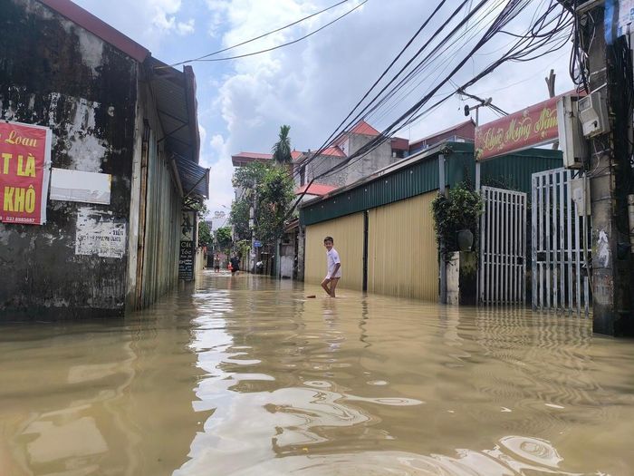 Một cháu học sinh đi học về, phải lội bì bõm để vào nhà