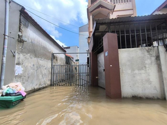 Nước ngập tới gần miệng thùng rác, khiến rác thải tràn cả ra ngoài gây mất vệ sinh môi trường