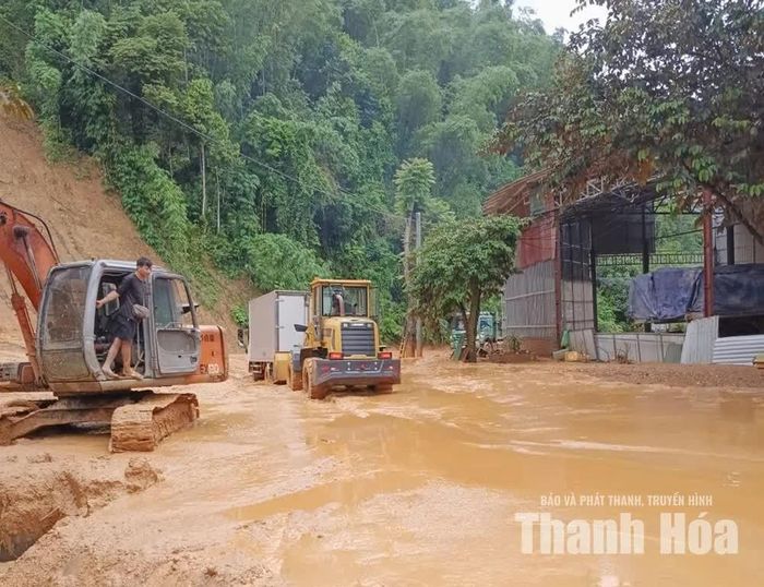 Máy móc được huy động thu dọn bùn đất để khôi phục giao thông trên Quốc lộ 217.
