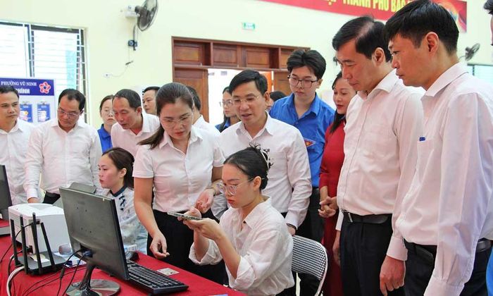 Các đại biểu theo dõi người dân thực hiện thủ tục hành chính trên cổng dịch vụ công trực tuyến tại điểm hỗ trợ Tổ dân phố Cô Mễ.