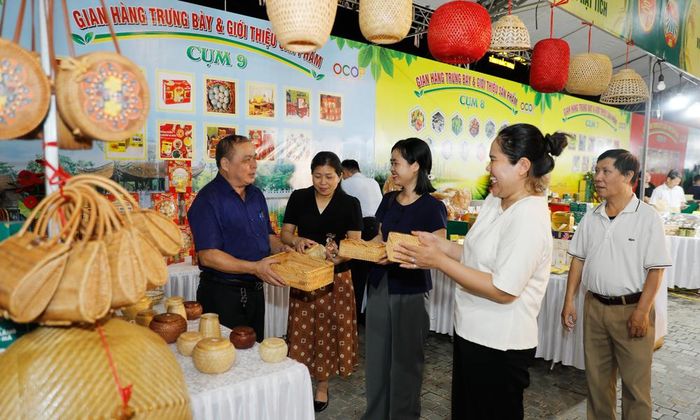 Ông Đặng Ngọc Phùng (ngoài cùng bên trái), Nghệ nhân Bàn tay vàng ngành thủ công mỹ nghệ, Giám đốc Hợp tác xã Mây tre đan xuất khẩu Phùng Hưng, xã Tân Chi (Bắc Ninh) giới thiệu sản phẩm mây tre đan xuất khẩu của đơn vị.