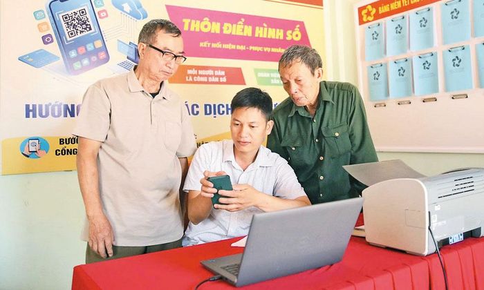 Thành viên Tổ công nghệ số thôn Việt Hương (xã Kép) hỗ trợ người dân nộp hồ sơ trực tuyến. Ảnh: Sơn Quang.
