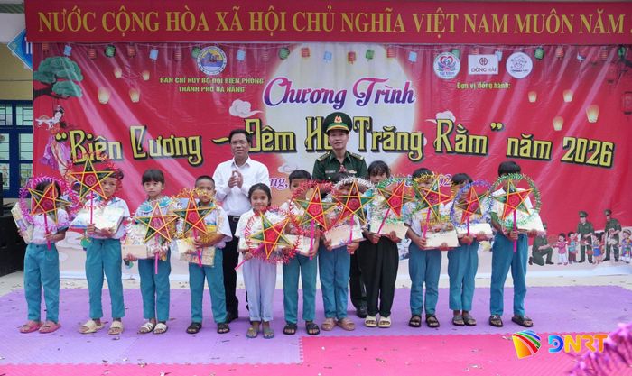 Đại tá Đinh Ngọc Anh, Phó Chủ nhiệm Chính trị Ban Chỉ huy Bộ đội Biên phòng thành phố và ông Arất Blúi, Chủ tịch UBND xã Tây Giang trao học bổng cho học sinh.