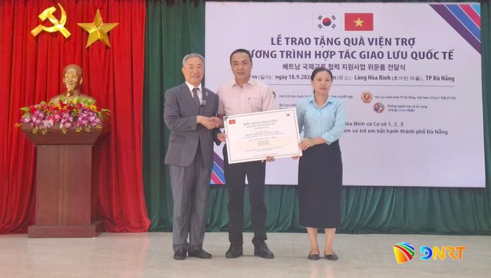 Chủ tịch Hội Cựu chiến binh Hàn Quốc tham chiến tại Việt Nam Lee Hwajong (ngoài cùng bên trái) trao quà viện trợ cho đại diện lãnh đạo Làng Hòa Bình. Ảnh: KIM NGÂN