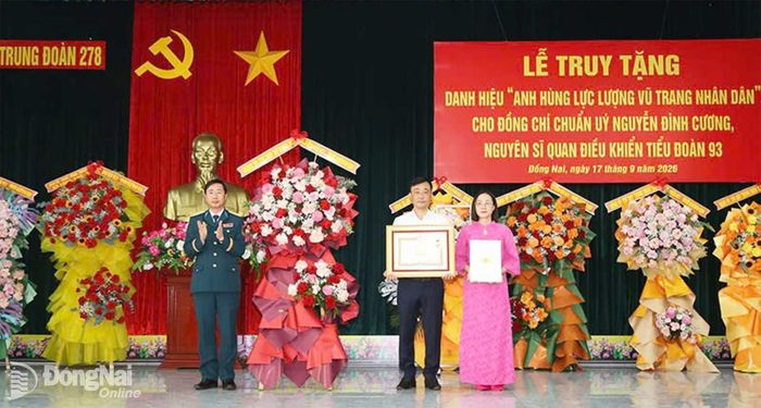 Thừa ủy quyền của Chủ tịch nước, Đại tá Đặng Hồng Tuân trao danh hiệu Anh hùng lực lượng vũ trang nhân dân cho đại diện gia đình Chuẩn úy Nguyễn Đình Cương. Ảnh: ĐVCC