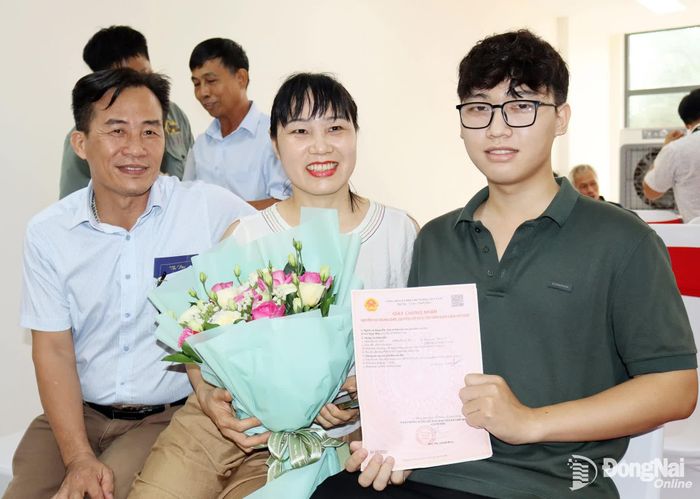 Một hộ dân vui mừng nhận sổ hồng tại dự án nhà ở xã hội. Ảnh: Hoàng Lộc