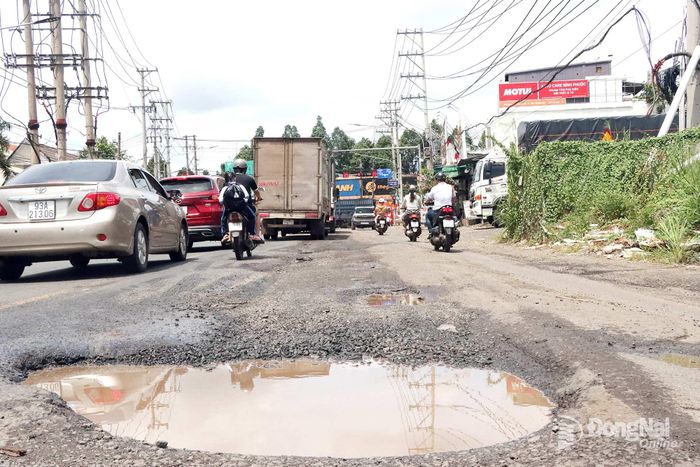 Một ổ gà có kích thước lớn tại khu vực ngã ba Trạm điện tiềm ẩn nguy hiểm trên đường Nguyễn Huệ. Ảnh: Quang Minh