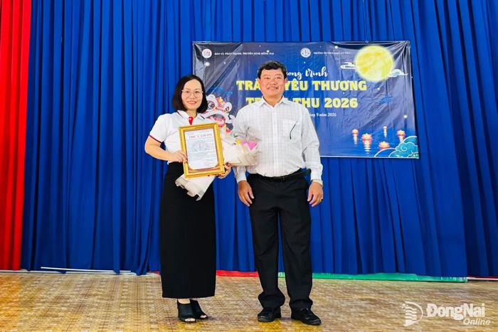 Thầy Trương Văn Minh, Hiệu trưởng Trường tiểu học và THCS Nam Cát Tiên trao thư cảm ơn Báo và Phát thanh, Truyền hình Đồng Nai vì đã đồng hành, chăm lo cho học sinh có hoàn cảnh khó khăn. Ảnh: Minh Huệ