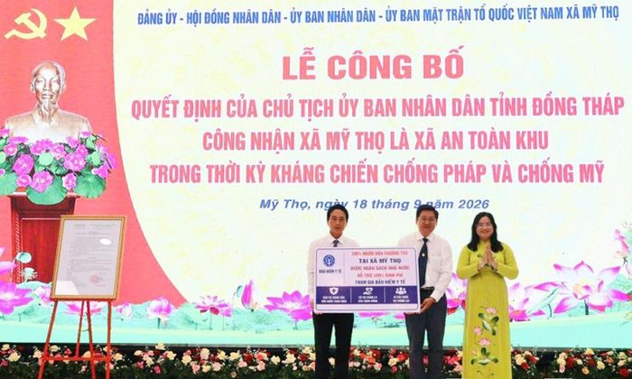 Đồng chí Huỳnh Thị Hoài Thu, Tỉnh ủy viên, Phó Bí thư Thường trực Đảng ủy UBND tỉnh trao biểu trưng chính sách hỗ trợ 100% kinh phí tham gia bảo hiểm y tế cho người dân thường trú tại xã Mỹ Thọ.