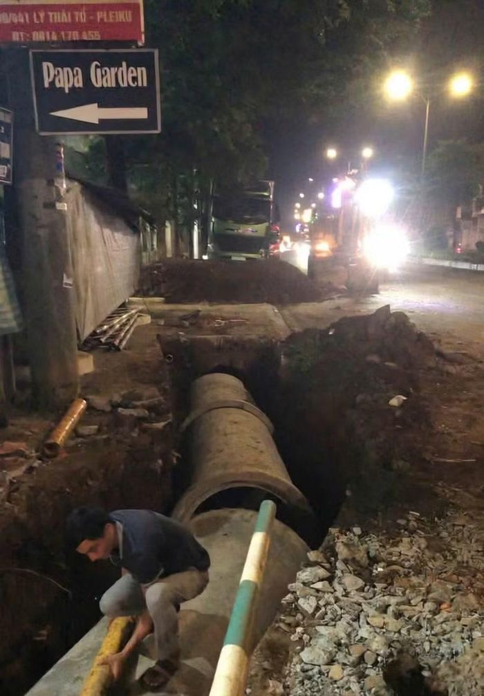 Công nhân Ban Quản lý dịch vụ công Quy Nhơn lắp đặt thêm cống thoát nước tại đầu hẻm 441 Lý Thái Tổ. Ảnh: Thúy Diện