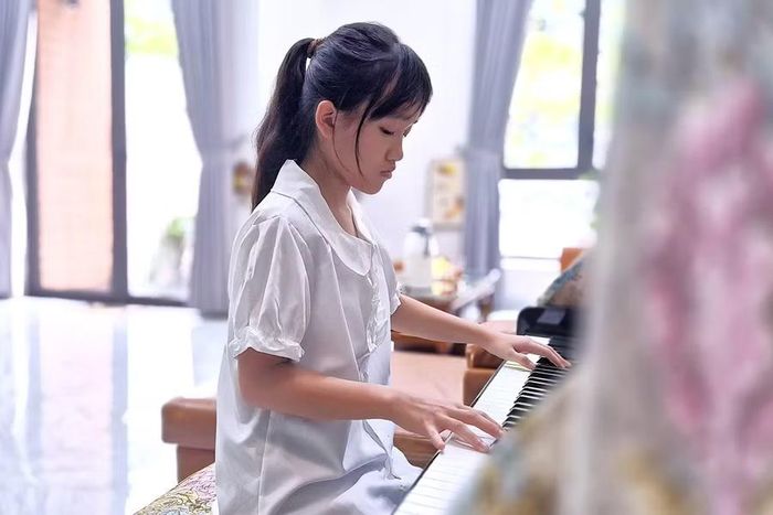 Em Nguyễn Thảo Dương say mê bên phím đàn piano. Ảnh: Thanh Sáng