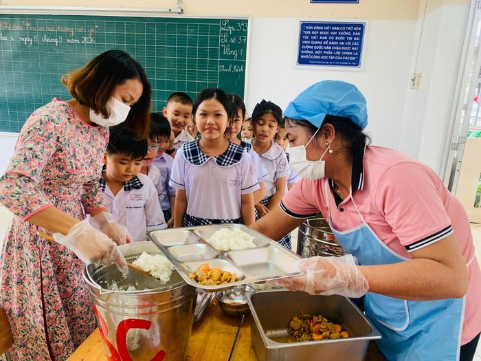 Giáo viên và bảo mẫu Trường TH Tiến Lợi chuẩn bị suất ăn cho học sinh
