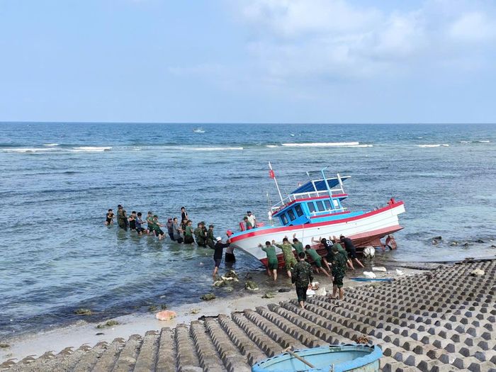 Tiểu đoàn Hỗn hợp Phú Quý hỗ trợ người dân di chuyển thuyền bị sóng biển đánh dạt vào bờ