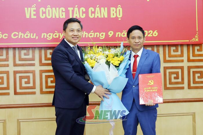 Đồng chí Chủ tịch UBND tỉnh trao quyết định và tặng hoa chúc mừng đồng chí Nguyễn Văn Phúc.