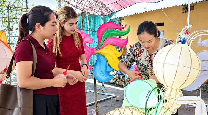 Du khách trải nghiệm làm đèn Trung thu tại tổ dân phố 1, phường Minh Xuân.
