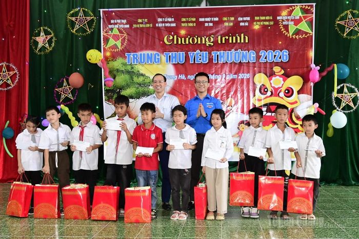 Lãnh đạo xã Trung Hà và nhà tài trợ trao quà cho các em học sinh.