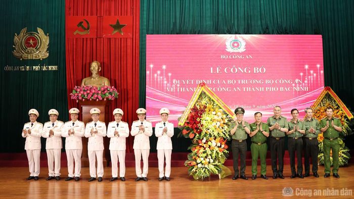 Bộ trưởng Lương Tam Quang và Thứ trưởng Nguyễn Văn Long cùng các đại biểu tặng hoa chúc mừng Ban Giám đốc Công an TP Bắc Ninh.