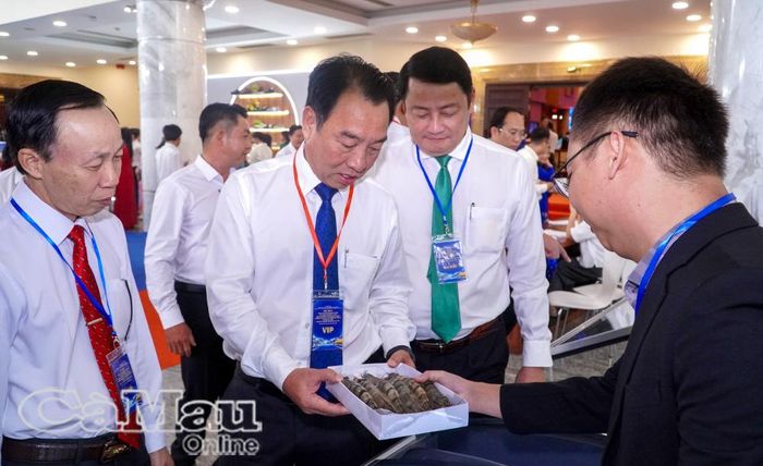 Đồng chí Lữ Quang Ngời, Phó Bí thư Tỉnh uỷ, Chủ tịch UBND tỉnh (thứ 2 từ trái sang) tham quan gian hàng trưng bày của tỉnh Cà Mau tại hội nghị.