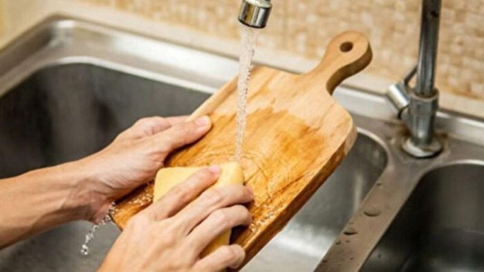 Bạn nên rửa thớt trực tiếp dưới vòi nước thay vì ngâm thớt quá lâu trong chậu. Ảnh minh họa