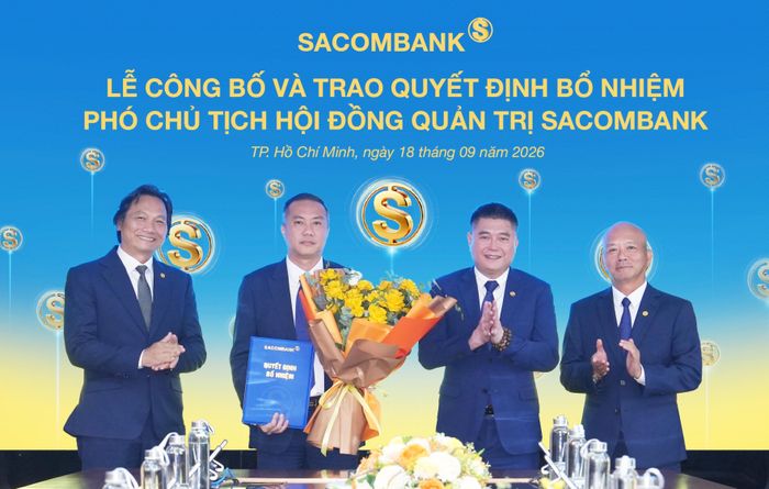 Ông Nguyễn Xuân Vũ (người cầm hoa) nhận quyết định bổ nhiệm từ HĐQT SACOMBANK. (Ảnh: Đại Việt)