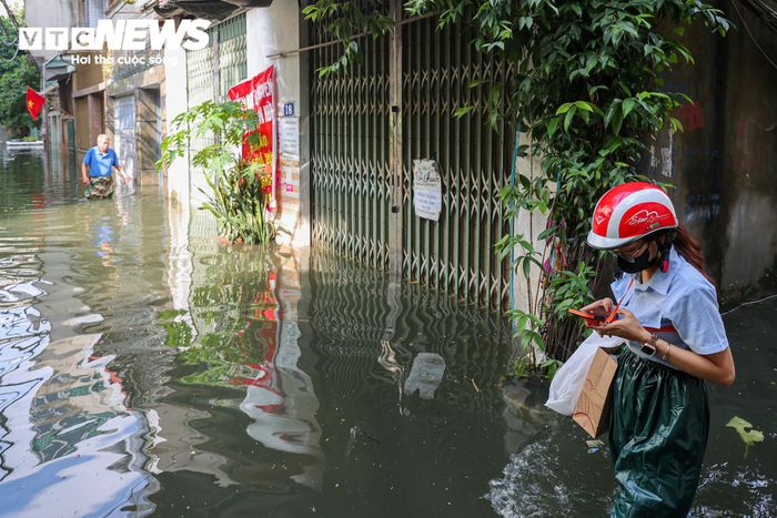 Một số người dân phải sử dụng phương tiện công cộng hoặc xe ôm để đi làm do xe máy không thể dắt ra khỏi khu vực ngập.