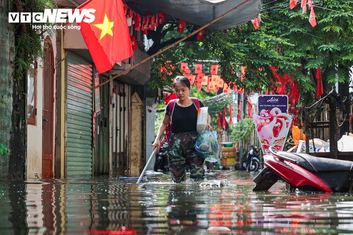 Vừa dùng gậy dò đường, vừa lội qua dòng nước vào nhà, một người dân ở đây cho biết do nước ngập sâu nên không thể nhìn thấy vị trí các miệng cống. Theo người dân này, trước đó, đã có người bị ngã khi di chuyển trong ngõ. “Đi lại trong nước ngập như này không nhìn thấy miệng cống thoát nước ở đâu. Vì thế hôm qua đã có người ngã nên tôi vừa đi vừa phải dò đường bằng gậy. Còn thực phẩm, đồ dùng phải chuyển từ ngoài vào, còn gia đình thì nấu nướng bằng bếp gas mini suốt 5 ngày nay”, người này nói.
