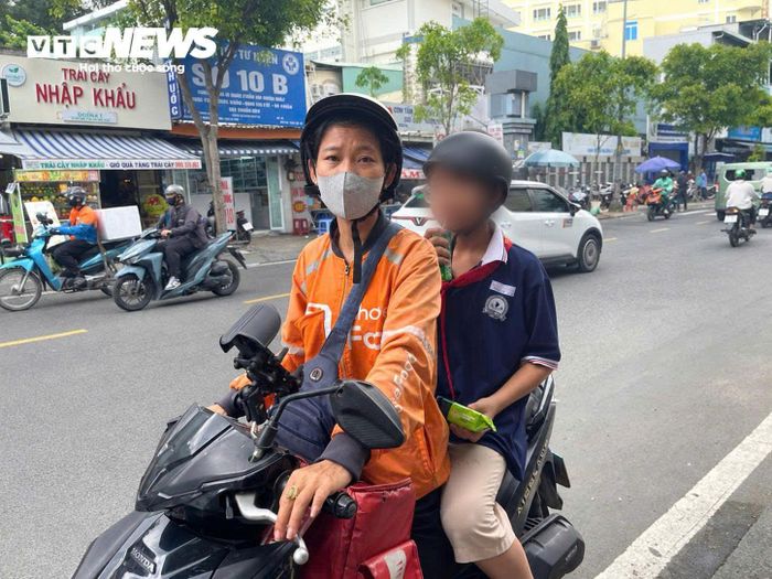 Chị Phụng tranh thủ vừa làm vừa đón con đi học về.