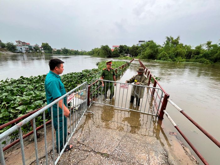 Lực lượng chức năng kiểm soát an toàn qua lại cây cầu Lam Điền. Ảnh: Tùng Nguyễn