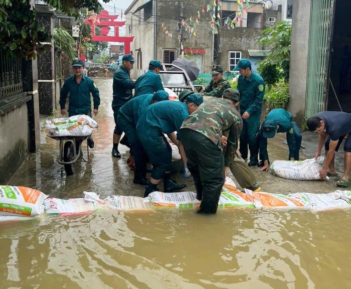 Xã Quảng Bị huy động hàng trăm cán bộ, chiến sĩ công an, quân đội chống lũ sông Bùi tràn vào khu dân cư. Ảnh: Vũ Liên