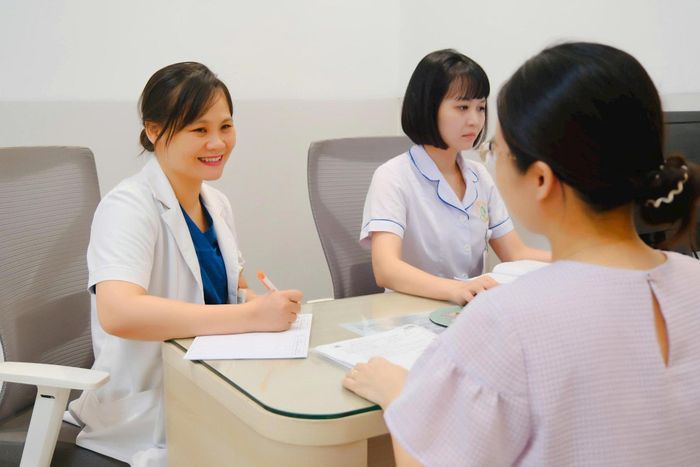 Thạc sĩ, bác sĩ chuyên khoa II Nguyễn Thị Minh Thanh (ngoài cùng bên trái), Trưởng khoa khám Chuyên gia, Bệnh viện Phụ sản Hà Nội, tư vấn cho người bệnh. Ảnh: Bá Thành