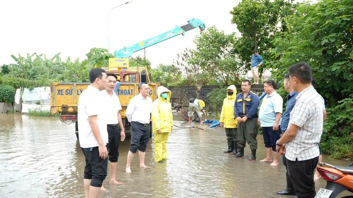 Chủ tịch UBND phường Yên Nghĩa Lê Xuân Hoàn kiểm tra, chỉ đạo xử lý tại một điểm ngập trên địa bàn. Ảnh: YN