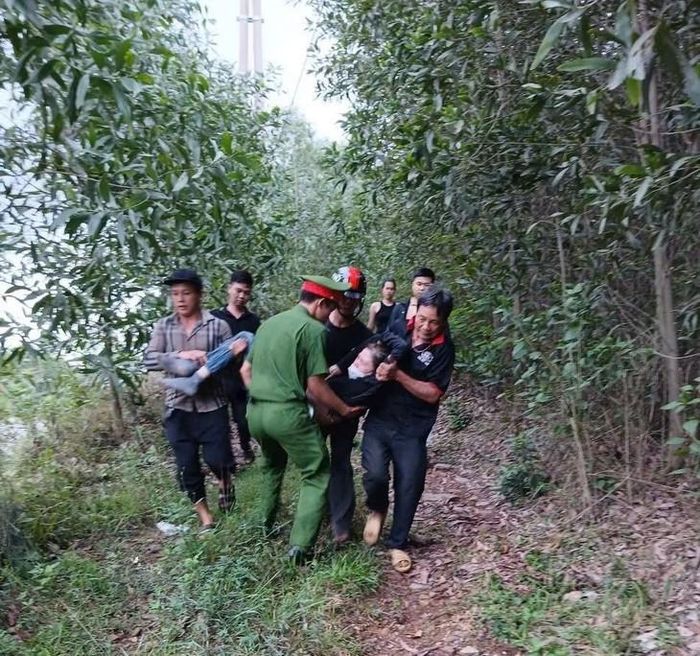 Người thân và công an địa phương giải cứu, đưa bà L. tới bệnh viện. Ảnh: CAXTT.