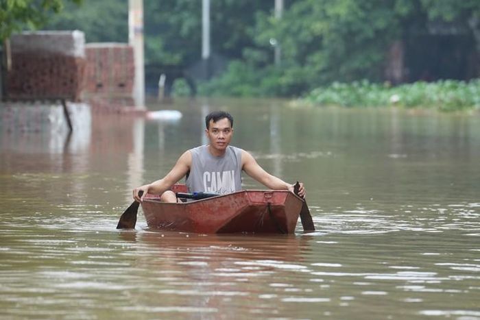 Một số khu vực hai bên cầu bị ngập, người dân dùng xuồng để di chuyển.