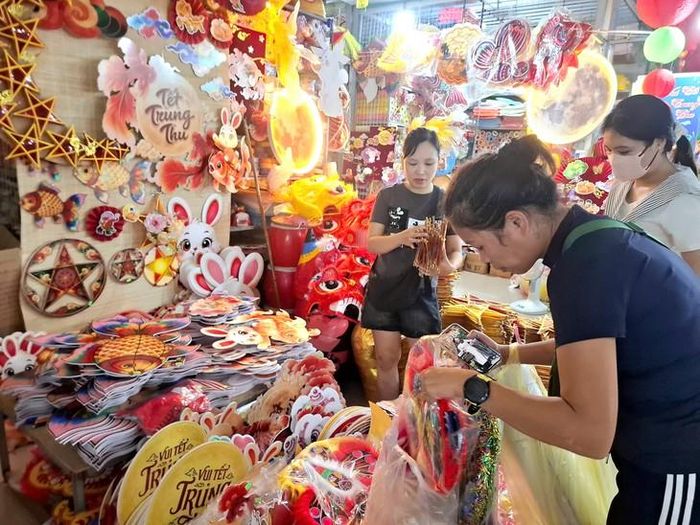 Chị Vân Anh (tay đeo đồng hồ) đang mua đồ trang trí Trung thu. Ảnh: Quỳnh Mai.