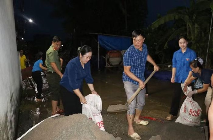 Hàng ngàn bao cát được lực lượng vũ trang và nhân dân đội mưa vận chuyển, đắp bờ bao ngăn nước trong đêm tối