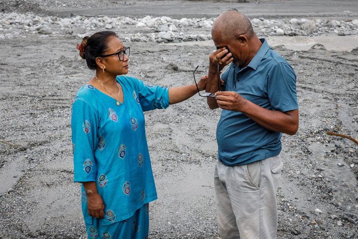  Chari Thapa Magar, 54 tuổi, và Sita Thapa Magar, 45 tuổi, những người bị mất nhà do lũ quét và sạt lở đất gần đây, khóc khi chụp ảnh trên lớp bùn vùi lấp ngôi nhà của họ ở Betrawati, huyện Nuwakot (Nepal) ngày 9/9. 